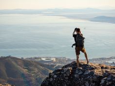 A man is taking a picture on top of the table mountain